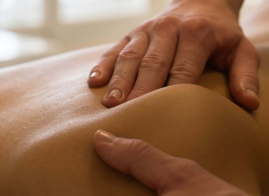 Kiropraktor i Eneby masserar en patients skuldra.