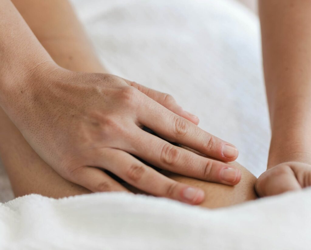 Kiropraktor i Fisksätra masserar en patients lår.